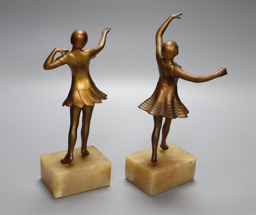 A pair of Art Deco gilt metal figures of young female dancers, on alabaster plinths, 25cm